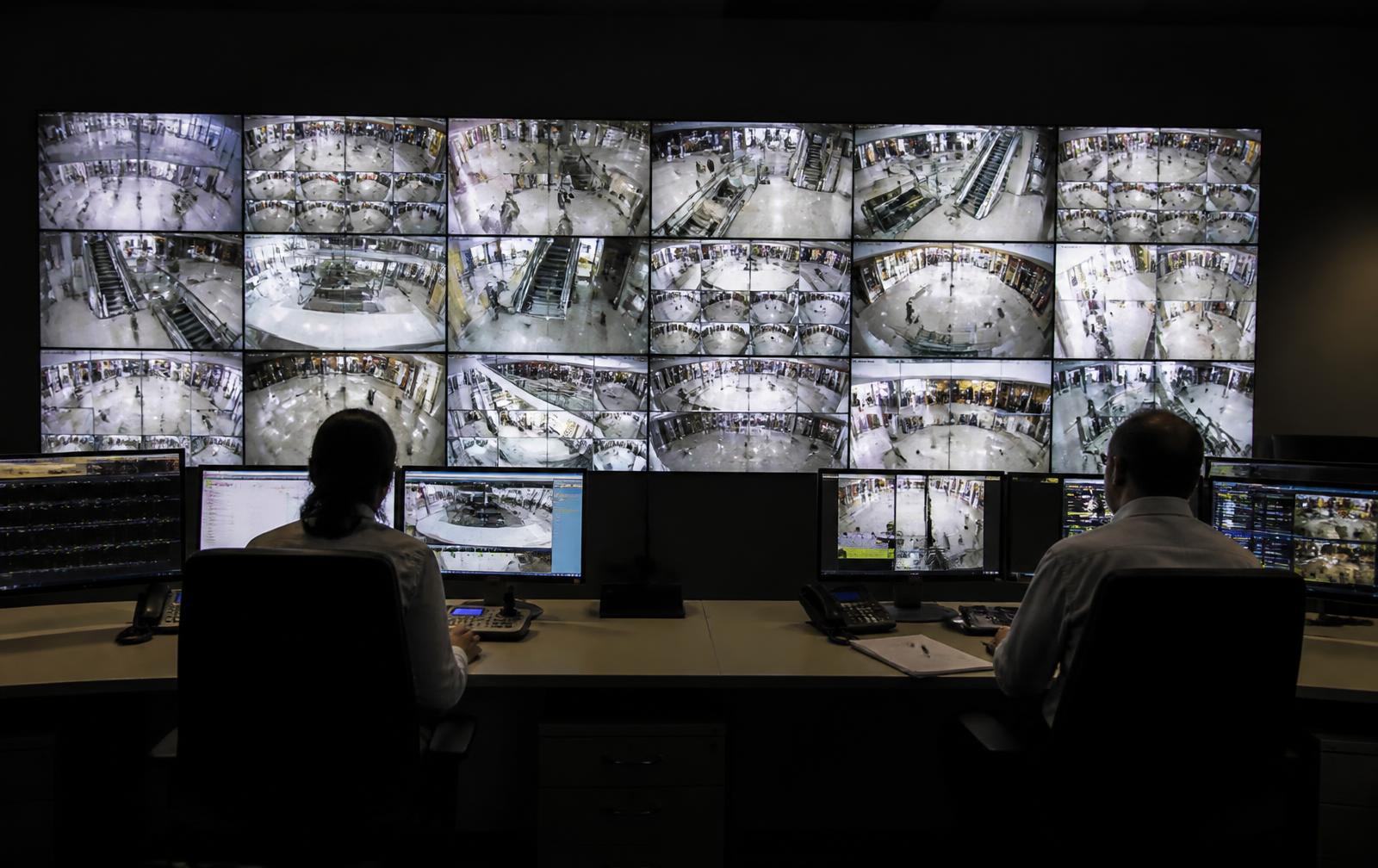 Central de monitoramento com videowall exibindo diversas câmeras de um shopping